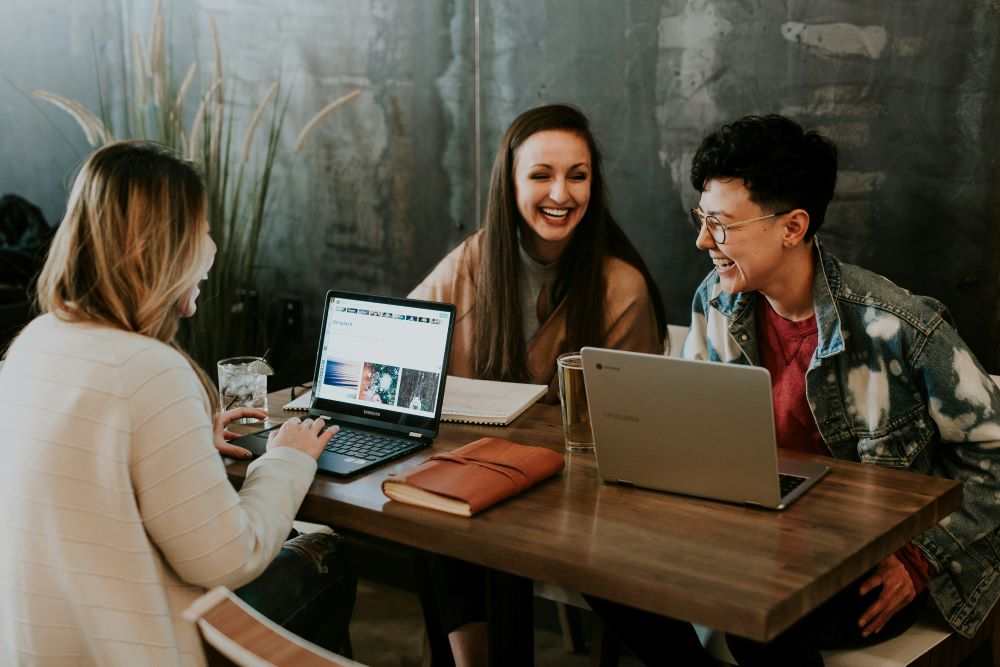 Inclusive language policies: An image of people around a table at work.