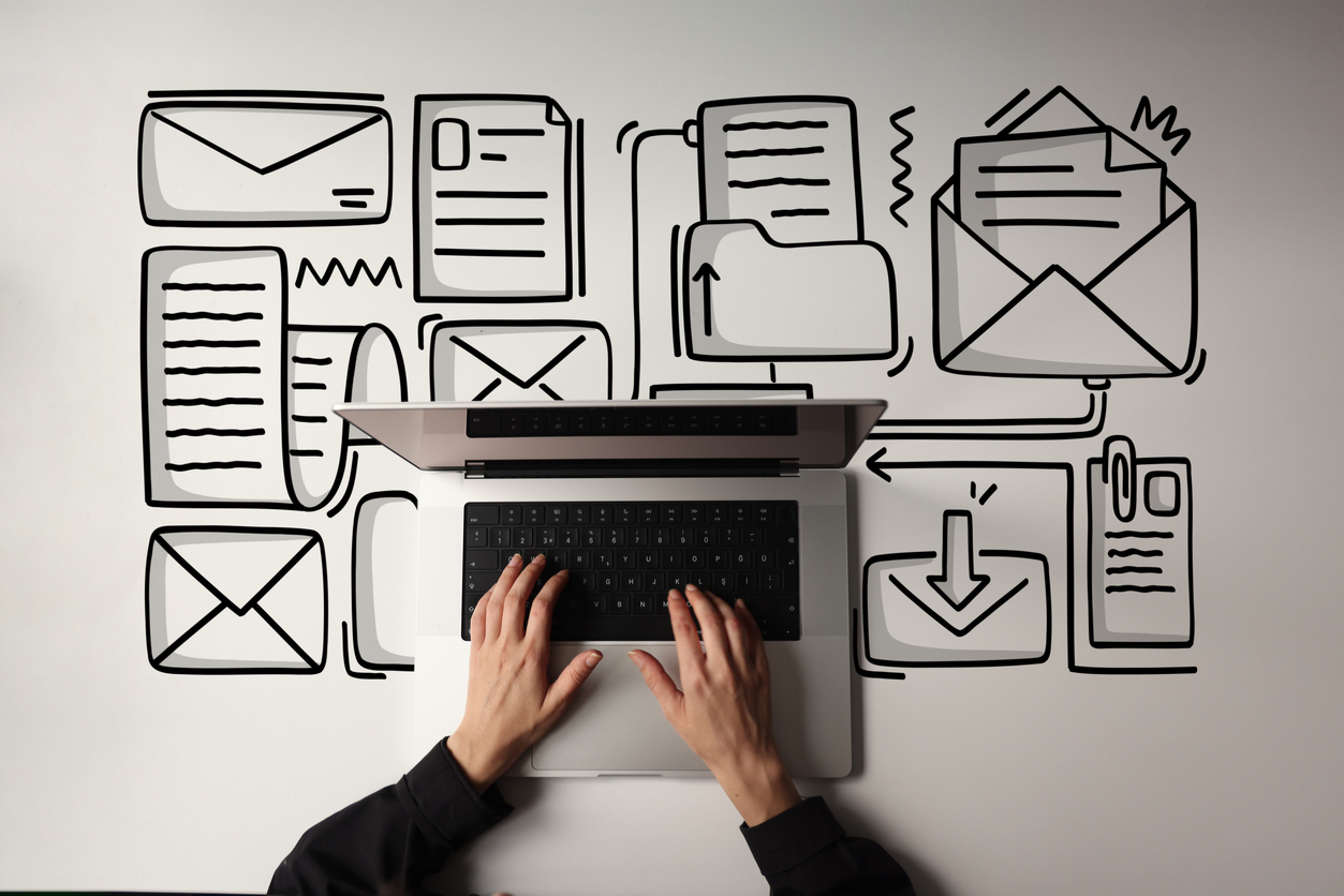 Woman using laptop with envelope icons